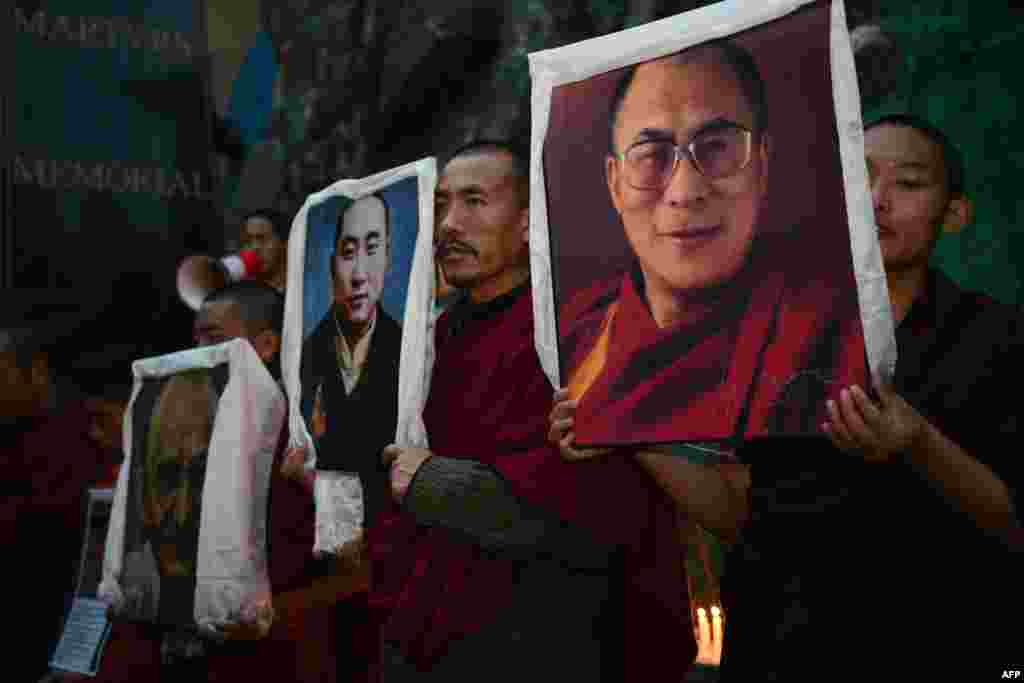 Hindistanda mühacirətdə olan tibetlilər Dalai Lama (sağ), sonuncu Panchen Lama (ortada) və Hindistanın müstəqillik ikonası hesab olunan Mahatma Gandhi-nin (sol) şəkillərini tutub 