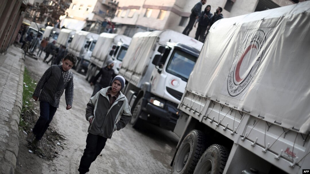 A Red Crescent convoy carrying humanitarian aid arrives in Kafr Batna, in the rebel-held Eastern Ghouta area, on the outskirts of the capital, Damascus, on February 23.