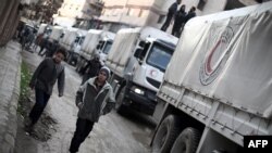 A Red Crescent convoy carrying humanitarian aid arrives in Kafr Batna, in the rebel-held Eastern Ghouta area, on the outskirts of the capital, Damascus, on February 23.