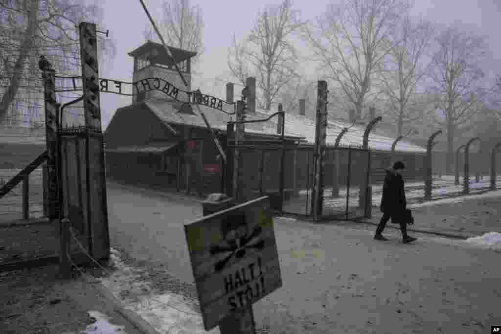 Un bărbat trece pe sub inscripția &bdquo;Arbeit Macht Frei&rdquo; (Munca te eliberează) de la poarta Memorialului și Muzeului Auschwitz-Birkenau, un fost lagăr de concentrare și de exterminare german nazist, din Oswiecim, Polonia, joi, 23 ianuarie 2025.&nbsp;&nbsp;