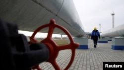 Un lucrător Gazprom în apropierea unei conducte de gaz, în Sudja, la frontiera dintre Rusia și Ucraina. 