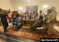 Taliban fighters inside the presidential palace after taking control of Kabul on August 15.