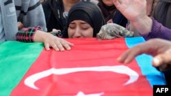 A woman cries at the coffin of an Azerbaijani soldier killed in fighting over the breakaway Nagorno-Karabakh region at a funeral ceremony in the Beylagan district on September 30.