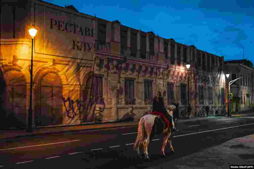 A woman rides her horse down a street in central Moscow.