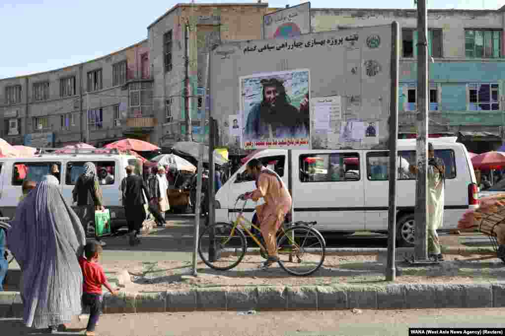 Njerëzit duke ecur në Kabul, para një portreti të një luftëtari të vrarë taliban. (1 shtator)