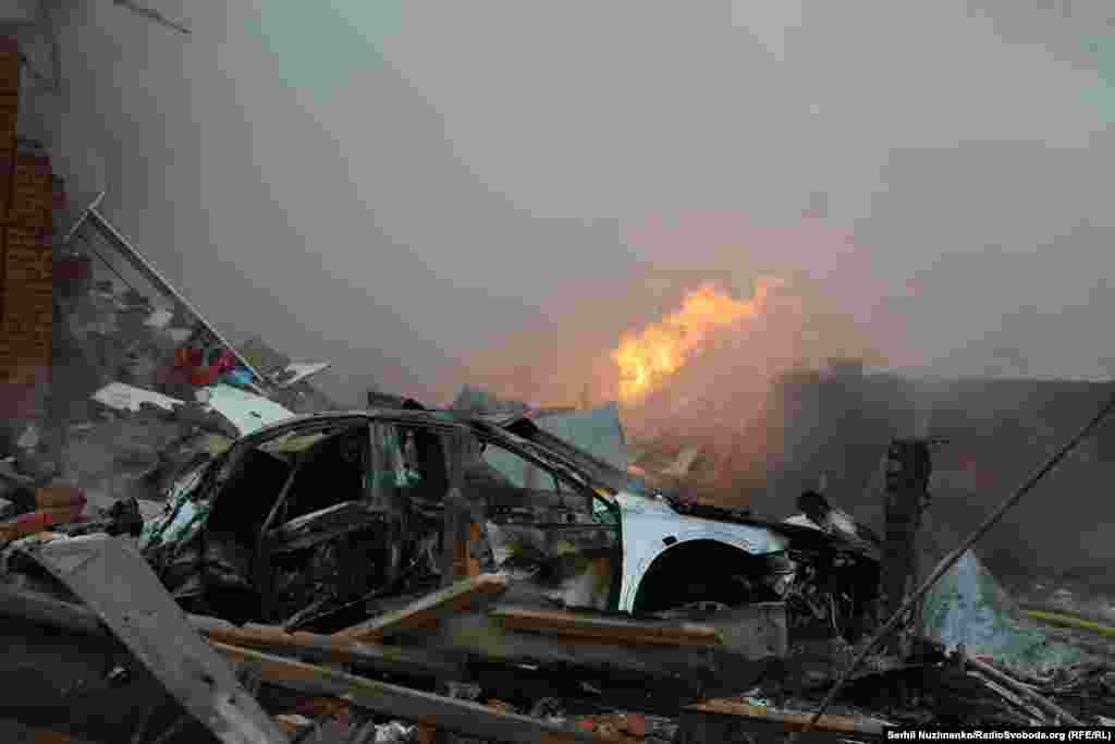 Знищена автівка на тлі руйнувань