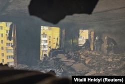Пожарные работают внутри жилого дома, пострадавшего от удара российского беспилотника, Харьков, 7 июня 2025 года