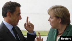 German Chancellor Angela Merkel (right) welcomes France's President Nicolas Sarkozy before talks in Berlin on July 20, where the two are said to have agreed a "common position" on the eurozone's debt crisis.