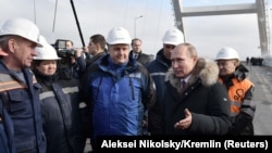 Russian President Vladimir Putin (second right) inspects a completed section of a bridge over the Kerch Strait that is meant to link Crimea to Russia. 