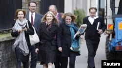 Ekaterina Zatuliveter (front, center) walks with lawyers to an immigration hearing in London in mid-October.