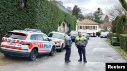 پولیس په جېنیوا کې د عمان د سفیر کور مخې ته، چې په اړه یې فکر کېږي چې پکې د امریکا او ایران استازو ترمینځ خبرې شوې وې، پهره کوي - د فبرورۍ ۱۷مې انځور.