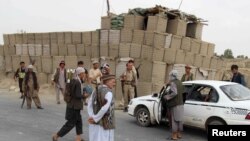 Afghan local police (ALP) keep watch at a checkpoint at Chardara district in Kunduz province on June 23.