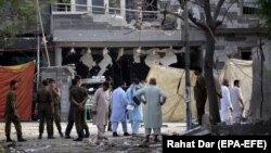 Pakistani security officials inspect the scene of a deadly bomb in Lahore that killed three people and wounded dozens. 
