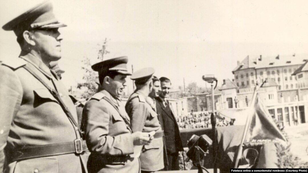 Craiova, 1950. Înmânarea drapelului roşu al U.T.C. unei organizaţii de tineret dintr-un regiment de artilerie din Tg.Jiu. Sursa: Fototeca online a comunismului românesc, cota: 12/1950