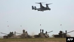 Un elicopter MV-22B Osprey deasupra unor tancuri ale armatei române în timpul exercițiului militar Vulturul de Platină '15, la terenul de instrucție de la Babagad, 26 mai 2015.