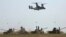 Un elicopter MV-22B Osprey deasupra unor tancuri ale armatei române în timpul exercițiului militar Vulturul de Platină '15, la terenul de instrucție de la Babagad, 26 mai 2015.