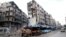 Syria -- Stalls are seen on a street beside damaged buildings in the rebel held al-Shaar neighborhood of Aleppo, February 10, 2016