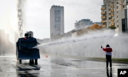 Police use a water cannon against demonstrators during a rally in Minsk on October 4.