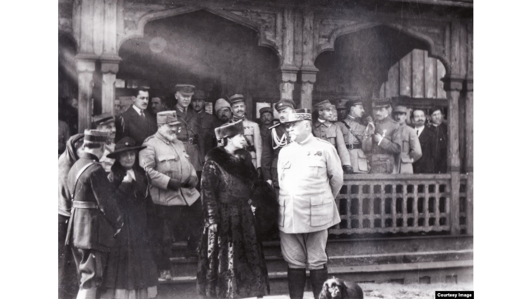 Regina Maria și generalul Henri Berthelot în primăvara lui 1917 la spitalul militar din Moldova rămasă liberă, construit de Misiunea Militară Franceză, înconjurați de ofițeri români, francezi și ruși. Muntenia și Dobrogea erau ocupate de trupe germane, turcești & bulgare.