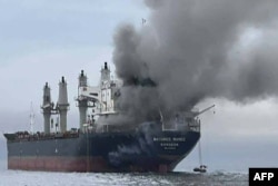 Smoke rises from the Thai bulk carrier Mayuree Naree near the Strait of Hormuz after an attack on March 11.