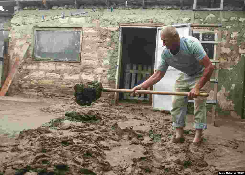 Чоловік у дворі підтопленого будинку в селі Красногірка Ленінського району Криму