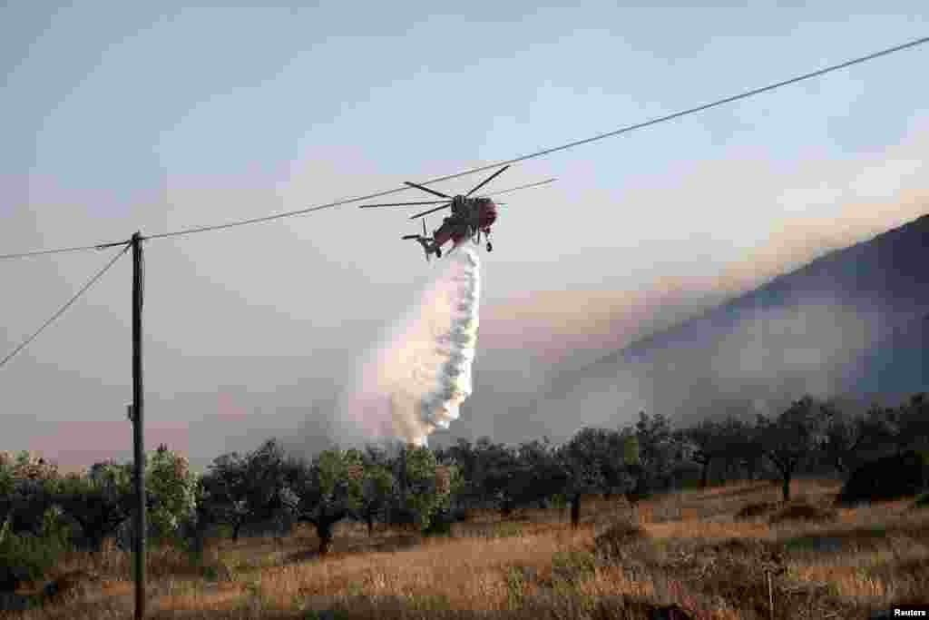 Një helikopter shihet duke tentuar të shuajë zjarret në ishullin Lesbos.