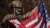 A 25-year-old volunteer fighter with the call sign Dima, who is from Texas and serves with the 23rd Separate Rifle Battalion of Ukraine's armed forces, holds the U.S. flag in his position near the front line in the Kharkiv region on October 26.