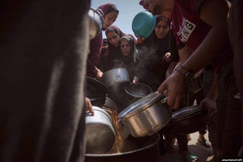 Palestinezë të zhvendosur duke marrë ushqim nga një kuzhinë popullore në Qytetin e Gazës, më 22 korrik.