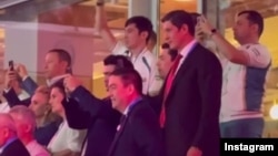 "Равшан Золотой" лақаби билан танилган Равшан Муҳиддинов (чапдан энг чеккада) Париждаги олимпия тадбирида президент куёви Отабек Умаров билан бир қаторда турган суратини тармоқда улашди. Instagram / 2024 йил, октябр