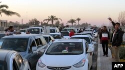 Iraqis drive their vehicles early on December 29 through the city of Ramadi, the capital of Iraq's Anbar Province, after Iraqi forces recaptured the city from Islamic State.