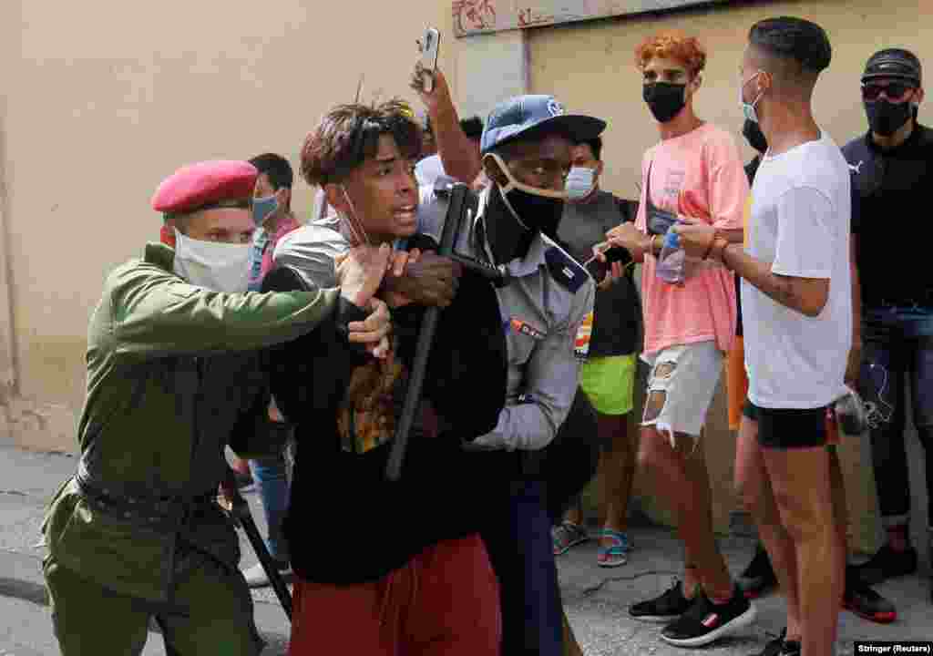 Policia arreston një person gjatë protestave për dhe kundër qeverisë kubane, në Havanë.