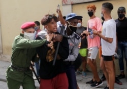 Полицейские задерживают одного из манифестантов. Гавана, 11 июля 2021 года