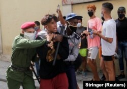 Полицейские задерживают одного из манифестантов. Гавана, 11 июля 2021 года