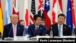 Japanese Prime Minister Shinzo Abe is flanked by U.S. President Donald Trump (left) and China's Xi Jinping in Osaka.