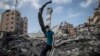 Palesztin férfi az éjjel lebombázott hatemeletes gázai ház romjai között. 2021. május 18.