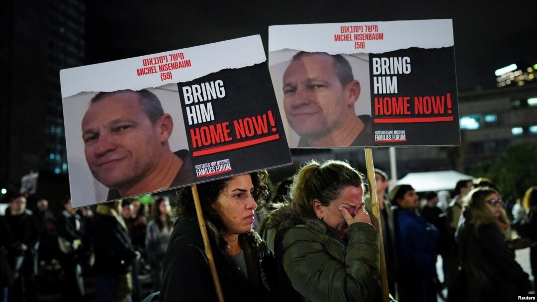 Ayala Harel ține o pancartă care îl înfățișează pe unchiul ei, pe 14 ianuarie 2024 în Tel Aviv, la o manifestare care a marcat 100 de zile de la atacul din 7 octombrie.