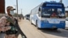 A soldier stands guard as buses carry pilgrims returning from Iran via the Pakistan-Iran border town of Taftan in March.