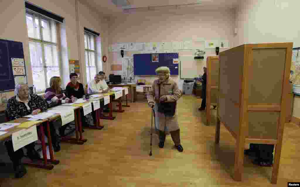 An elderly woman leaves a polling station in Prague.