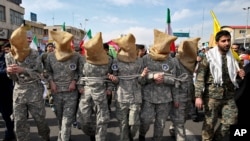 Members of Iranian Basij paramilitary force reenact the January capture of U.S sailors by the Revolutionary Guards in the Persian Gulf, in a rally commemorating the 37th anniversary of Islamic Revolution in Tehran, Feb. 11, 2016. 