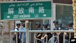 Armed members of China's special police corps stand guard near the site of an attack in Kashgi in the far-western Xinjiang Uygur Autonomous Region