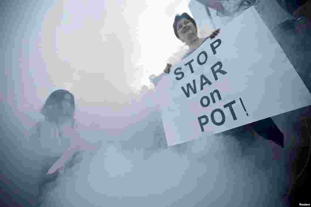 A girl dances as another holds a sign during a rally in support of the decriminalization of marijuana in Tbilisi, Georgia. (Reuters/David Mdzinarishvili)