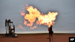 Zjarri shihet pranë një pusi prej ku nxirret gazi natyror në Dakotën Veriore në SHBA, 26 gusht, 2021. 