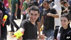 Young people shoot with water guns during a mass organized water fight in northern Tehran 