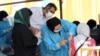 People receive a COVID-19 vaccine at a drive-in vaccination station at the Azadi sport complex in Tehran on September 16.