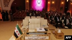 На саміті Ліги арабських держав на столі делегації Сирійської Арабської Республіки стоїть «прапор незалежності» 1930–50-х років, який використовує сирійська опозиція, 26 березня 2013 року