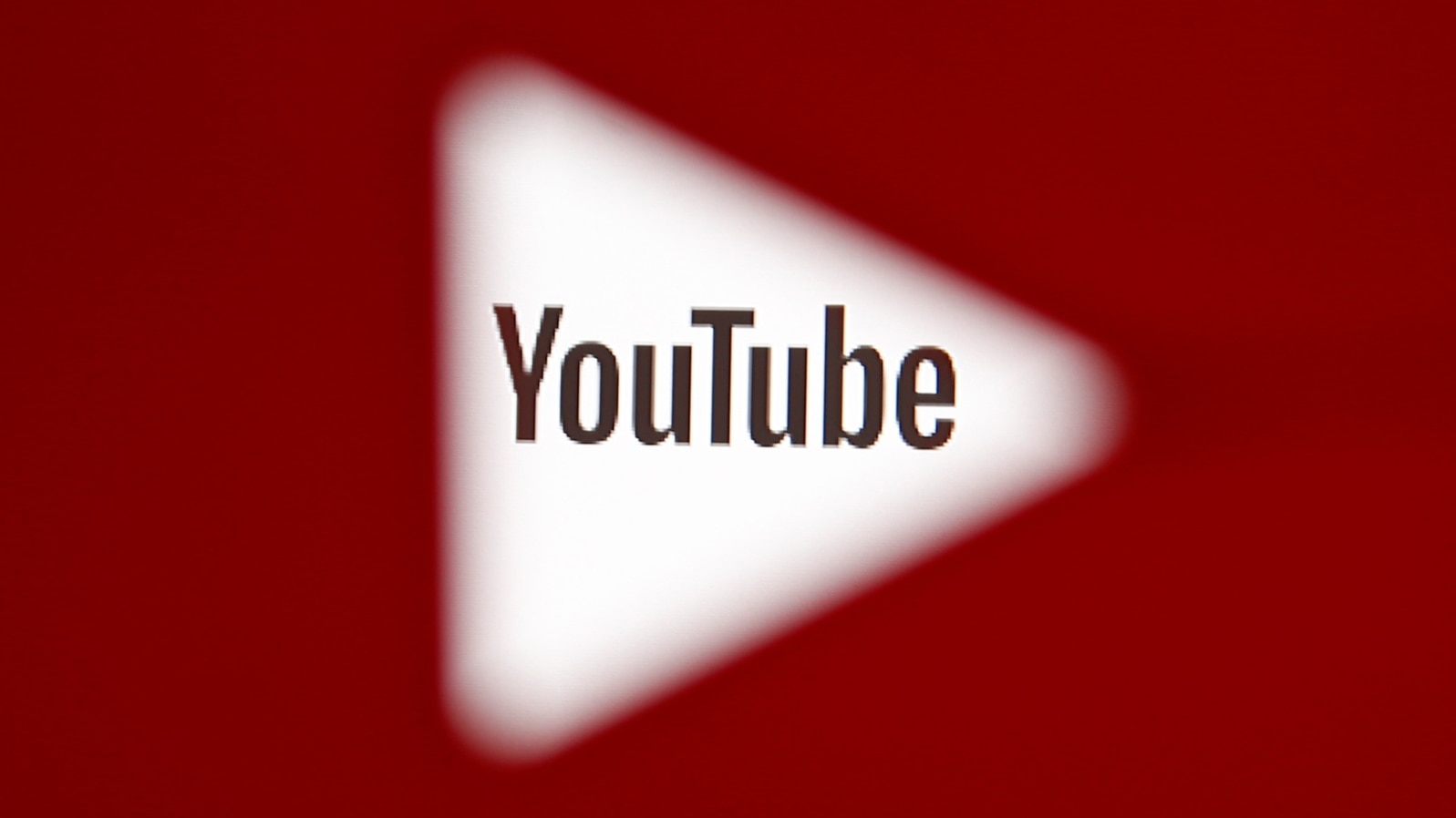 A 3D-printed YouTube icon is seen in front of a displayed YouTube logo - generic