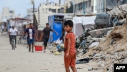 Një fëmijë palestinez ec nëpër një rrugë të mbushur me gërmadha në Han Junis, në jug të Gazës, midis luftës mes Izraelit dhe Hamasit, 6 korrik 2024.