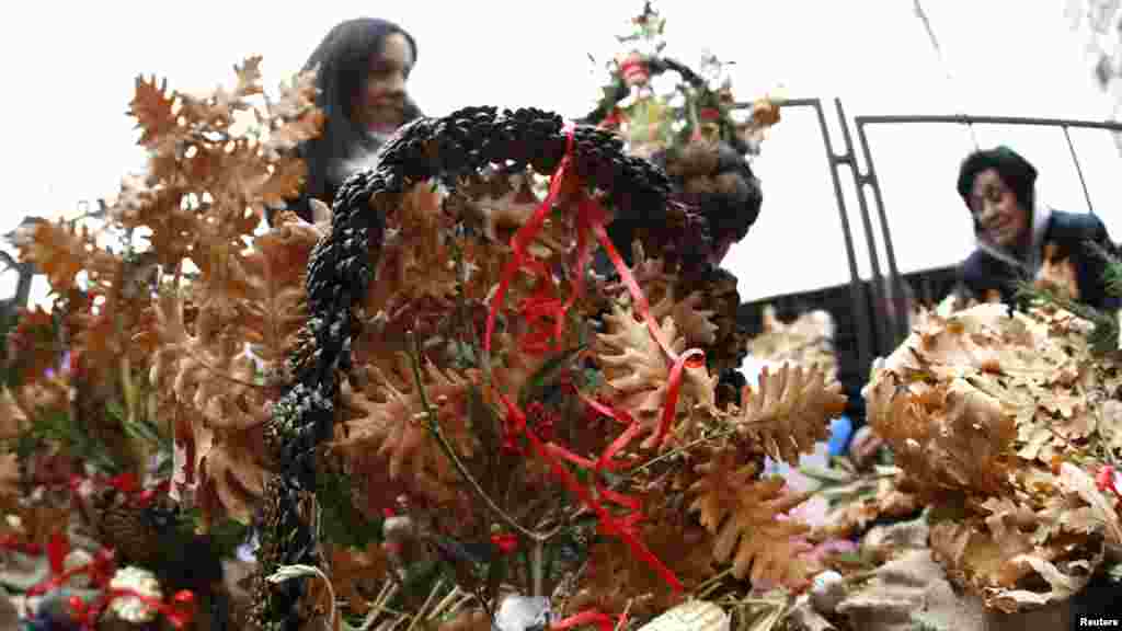 Women buy dried oak branches and wheat, symbols of the traditional Yule log, in Belgrade, Serbia. REUTERS/Ivan Milutinovic