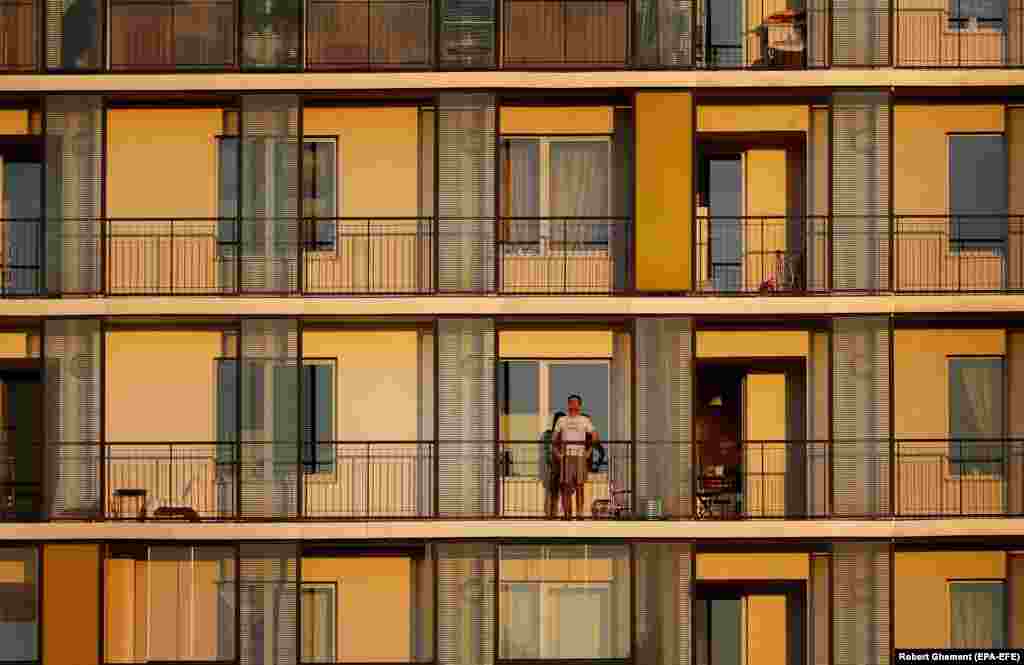 A Romanian man watches the sunset from the balcony of his flat in Bucharest. (epa-EFE/Robert Ghement)&nbsp;&nbsp;