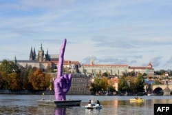 Скулптурата на среден пръст на фона на Пражкия замък, 21 октомври 2013 г.